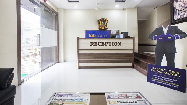 A hotel reception area with a reception desk labeled "fabHOTELS RECEPTION," a framed picture on the wall, and a poster on the floor advertising a social media challenge. - FabHotel Parimeet Navi Mumbai (Navi Mumbai)