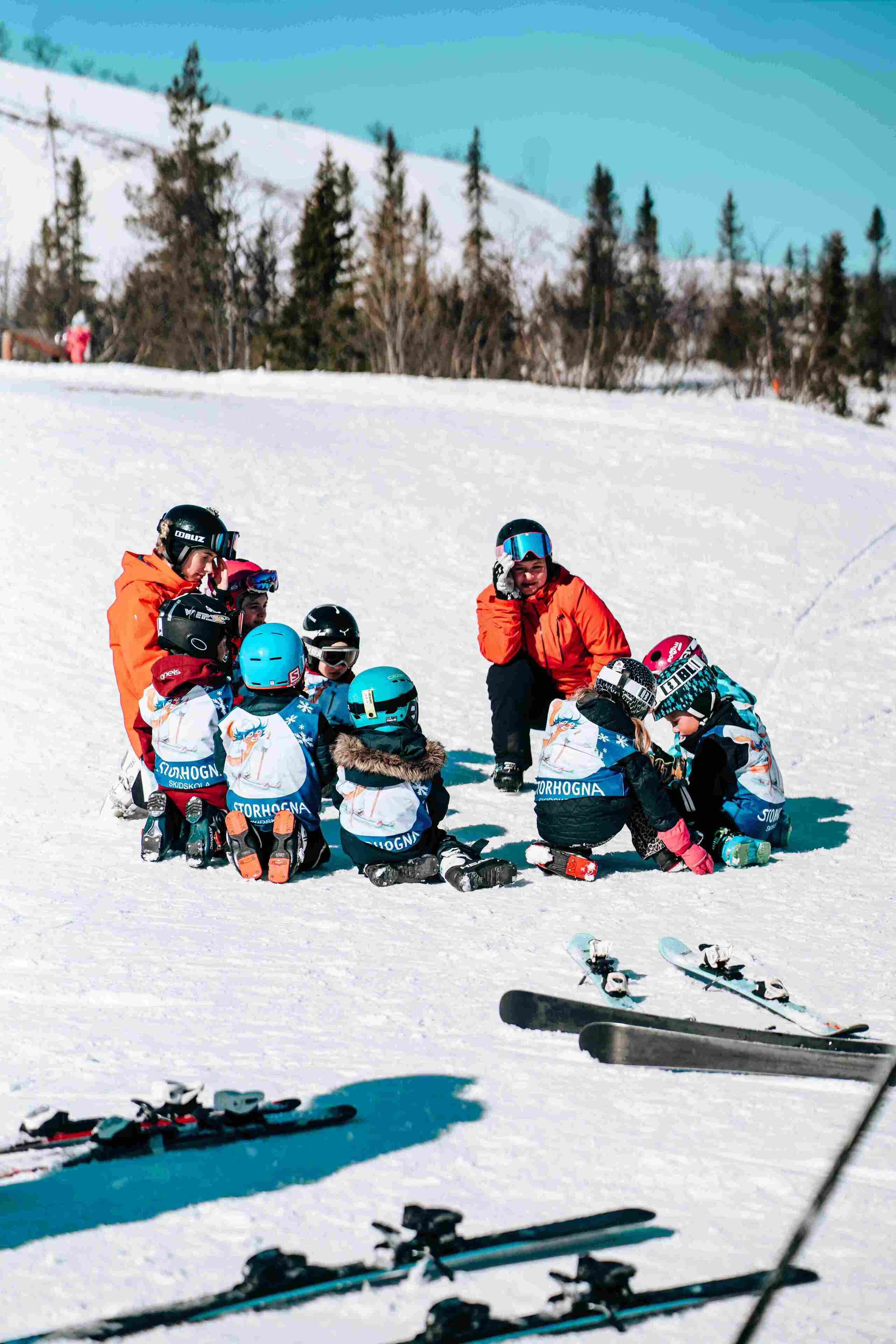 Un grupo de personas en una ladera nevada, con esquíes y tablas de snowboard.