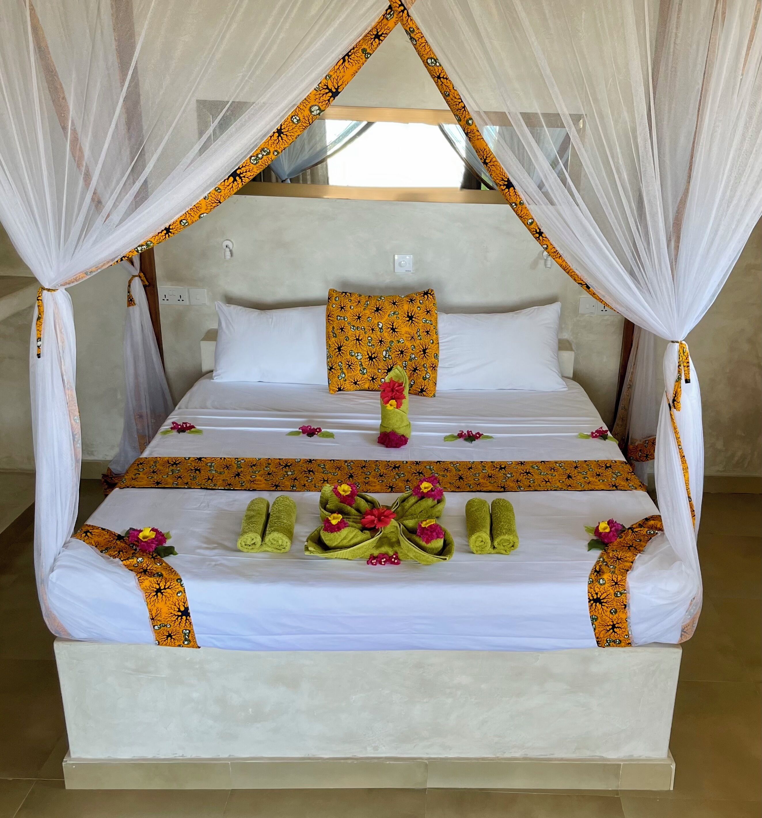 A bed with a canopy, white bedding, and decorative pillows.