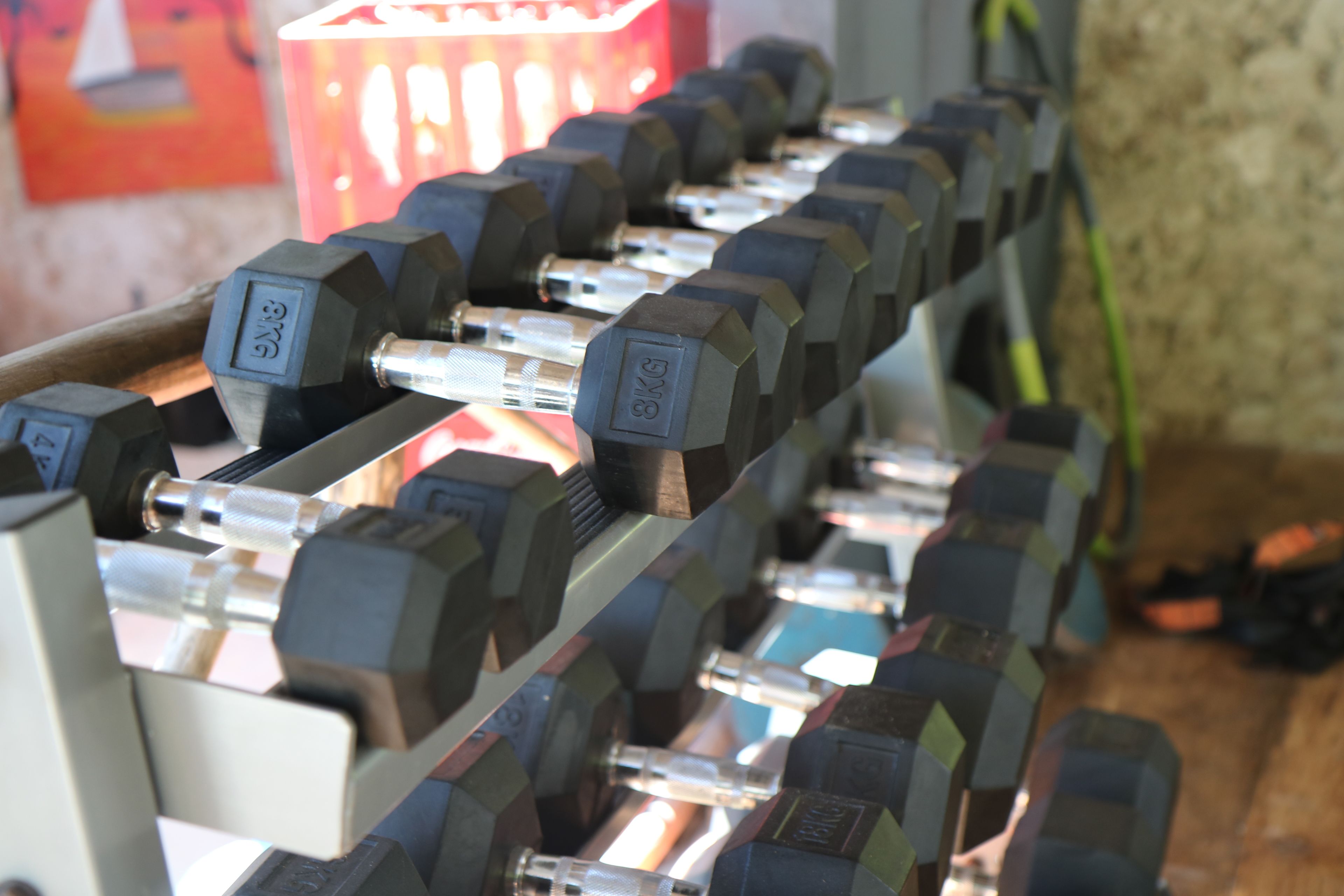 A rack of 8KG dumbbells in a gym setting.