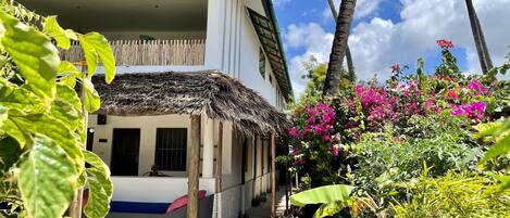 A two-story building with a thatched roof and a balcony.