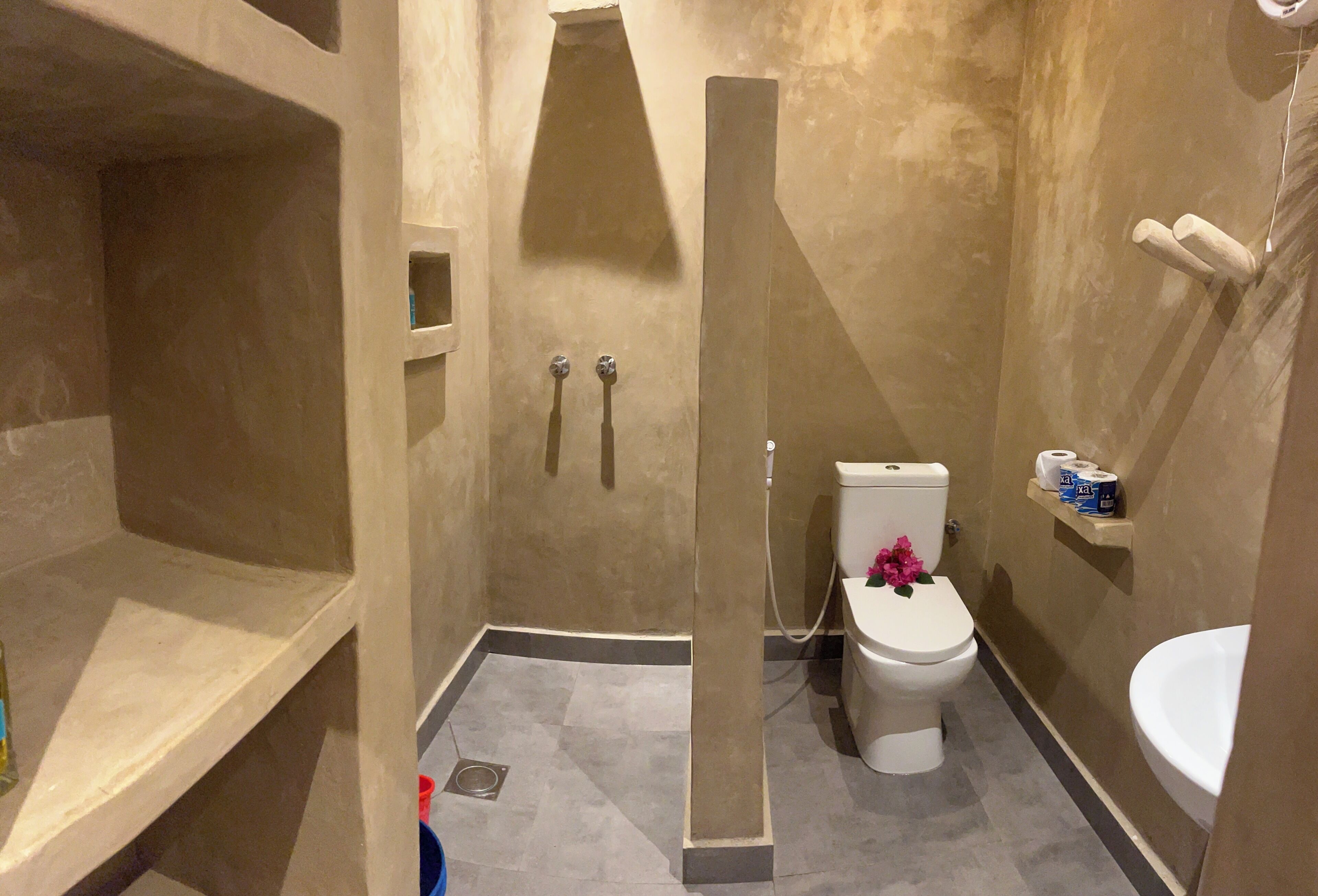 A bathroom with a shower, toilet, and sink.