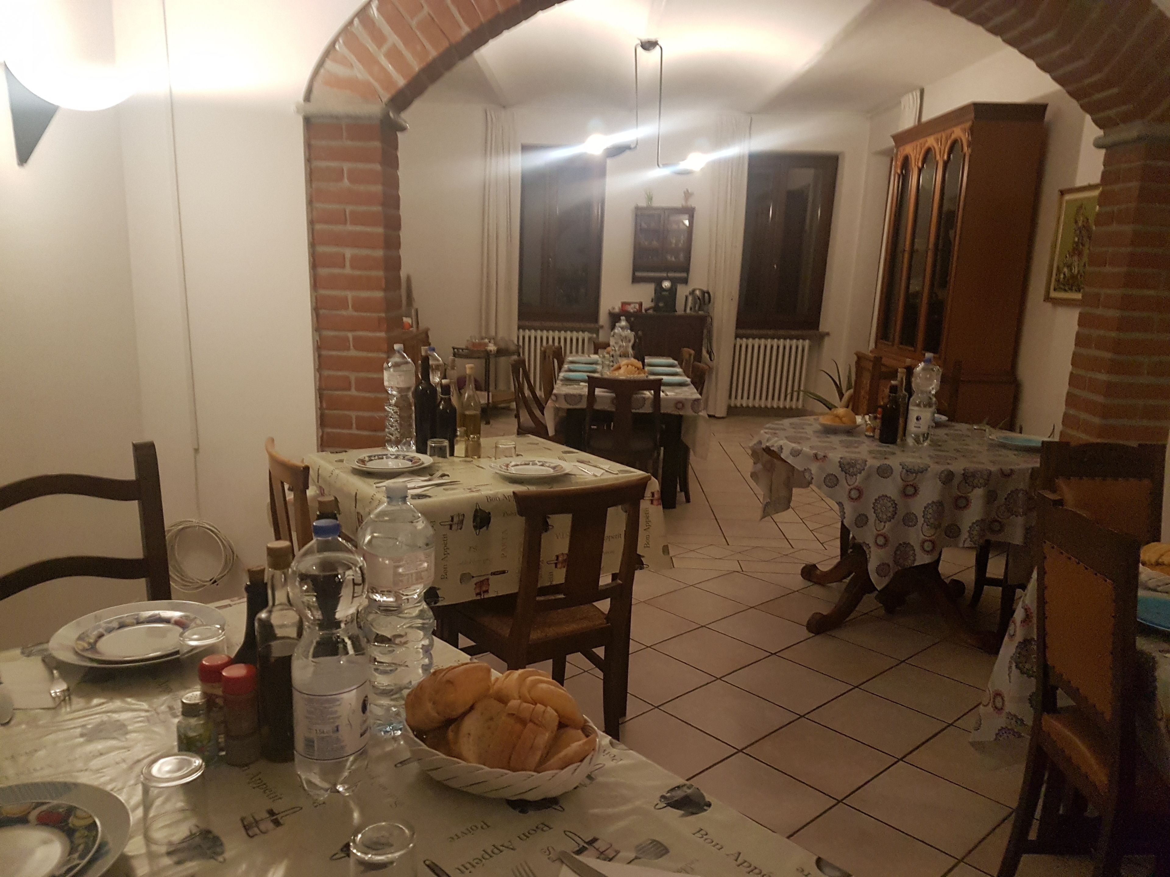 Ein Essbereich mit zwei gedeckten Tischen, umgeben von Stühlen.