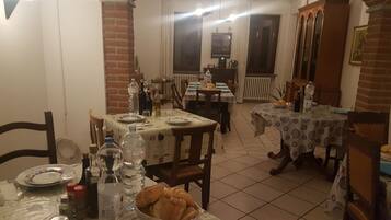 Ein Essbereich mit zwei gedeckten Tischen, umgeben von Stühlen.