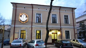A building with a sign that reads "Politia" and several parked cars in front. - Porto Franco Residence (Braila)