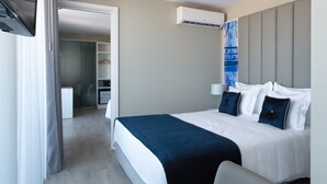 Una habitación de hotel moderna con cama, mesita de noche y armario.