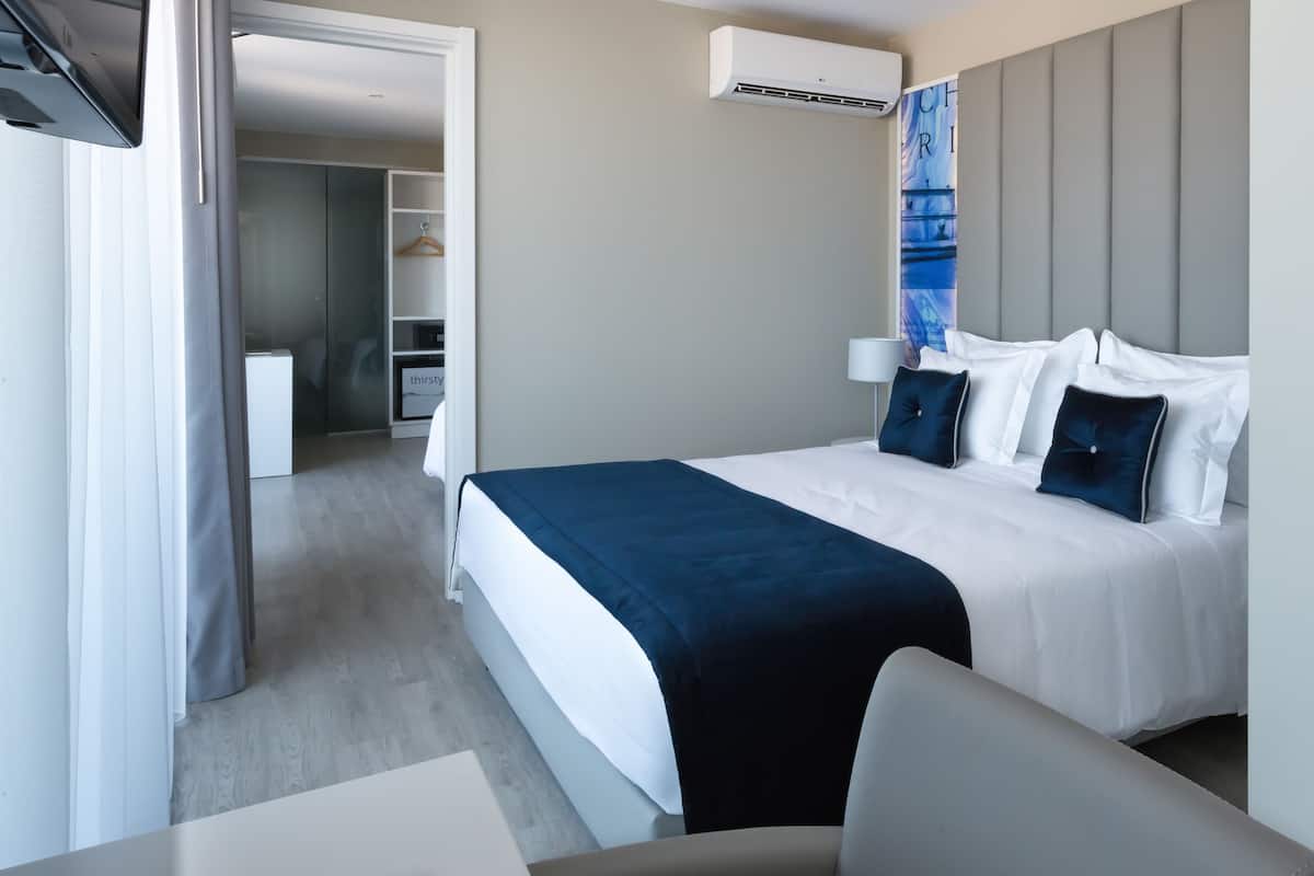 Ein modernes Hotelzimmer mit einem Bett, einem Nachttisch und einem Kleiderschrank.