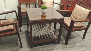 A common room with a wooden table, four chairs, and a decorative vase. - The Backpacker Station (Pak Kret)