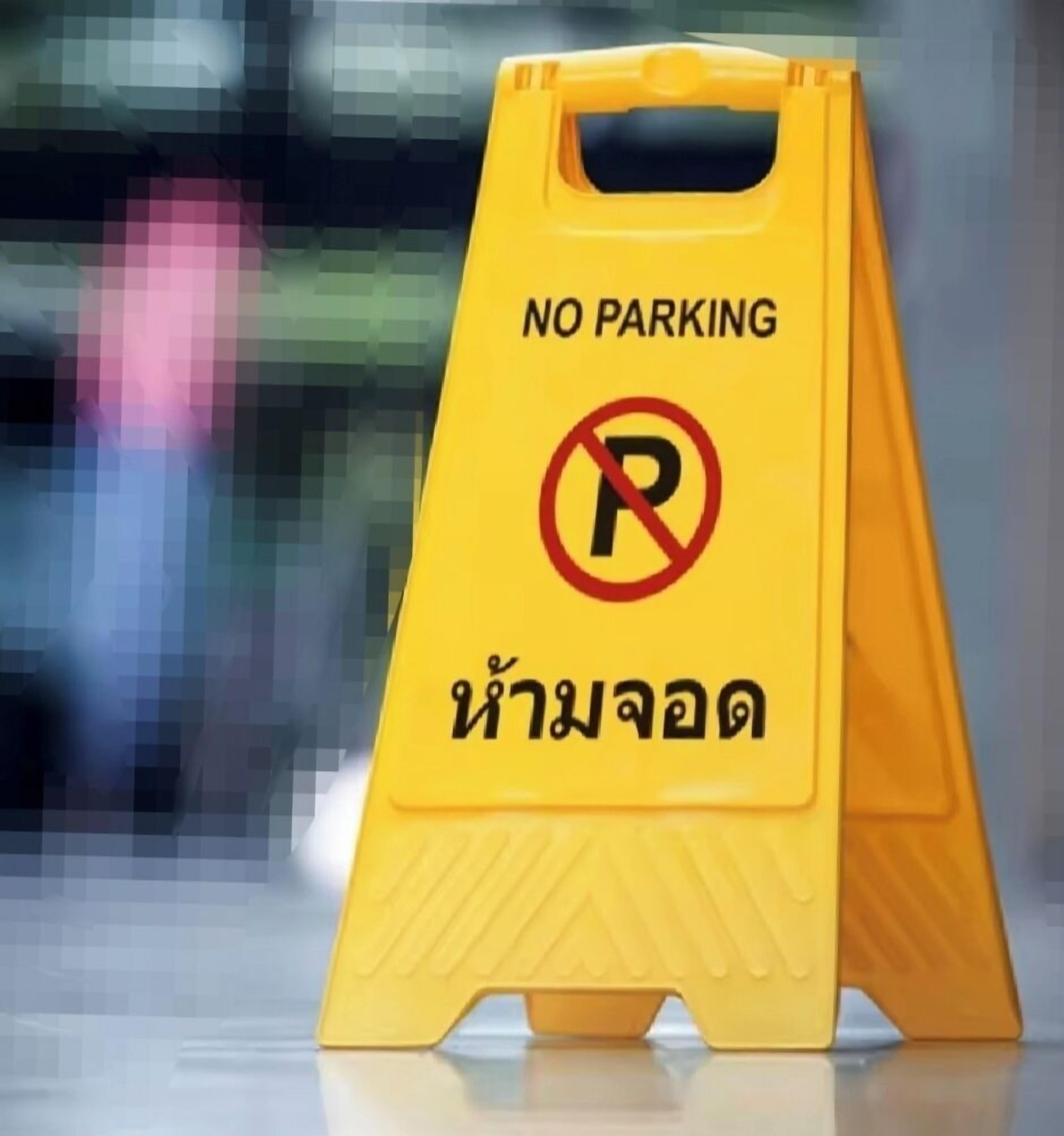 A yellow no parking sign with Thai text.