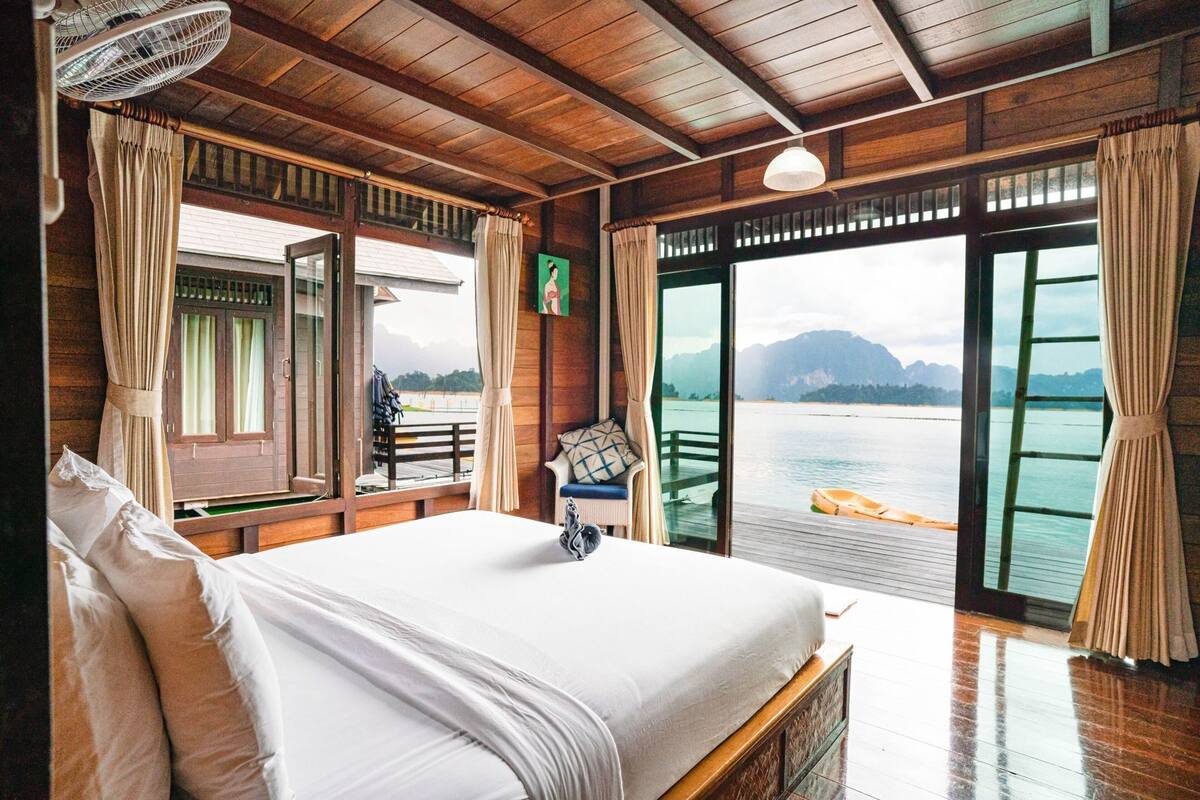 Ein Holzhütten-Zimmer mit Bett, Seeblick und Balkon.