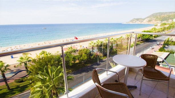 Un balcone con vista sulla spiaggia, un tavolo e due sedie.