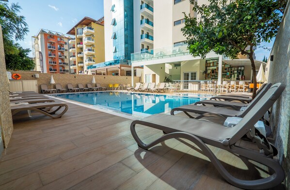 Alberca al aire libre, sombrillas en la alberca y camastros 