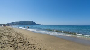 A beach with clear skies, a sandy shore, and a distant hill. - Kleopatra Celine Hotel (Alanya)