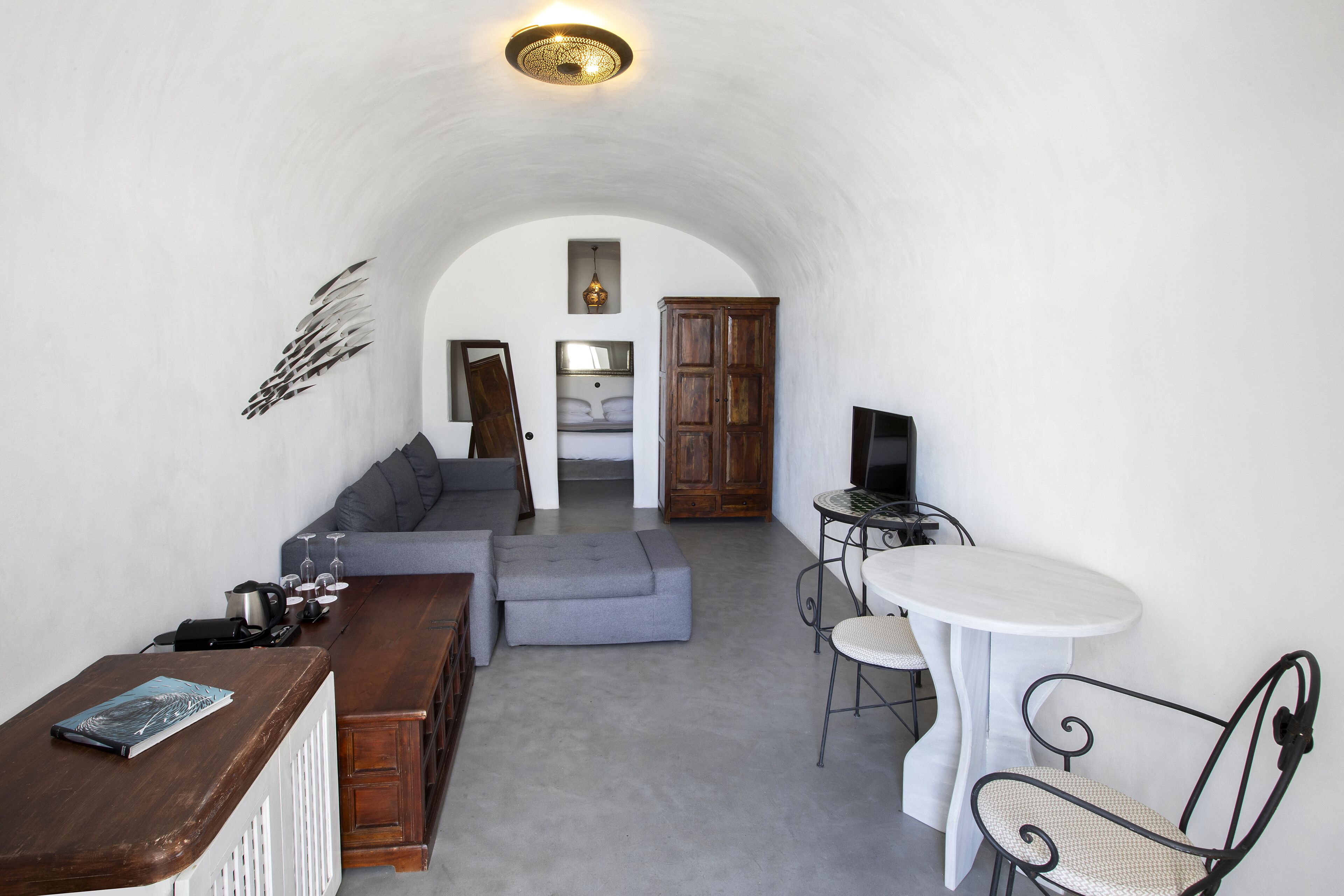 A cozy living area with a sofa, a coffee table, a dining table with chairs, and a TV.