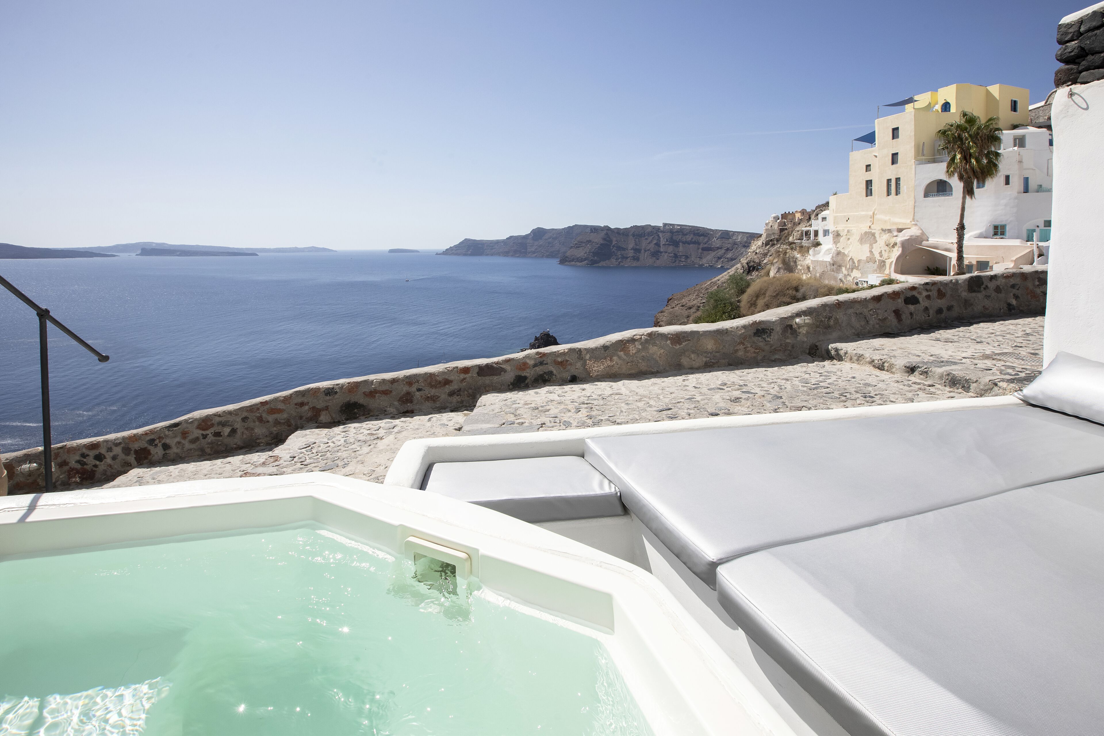 Área da piscina com vista para o mar e edifícios.