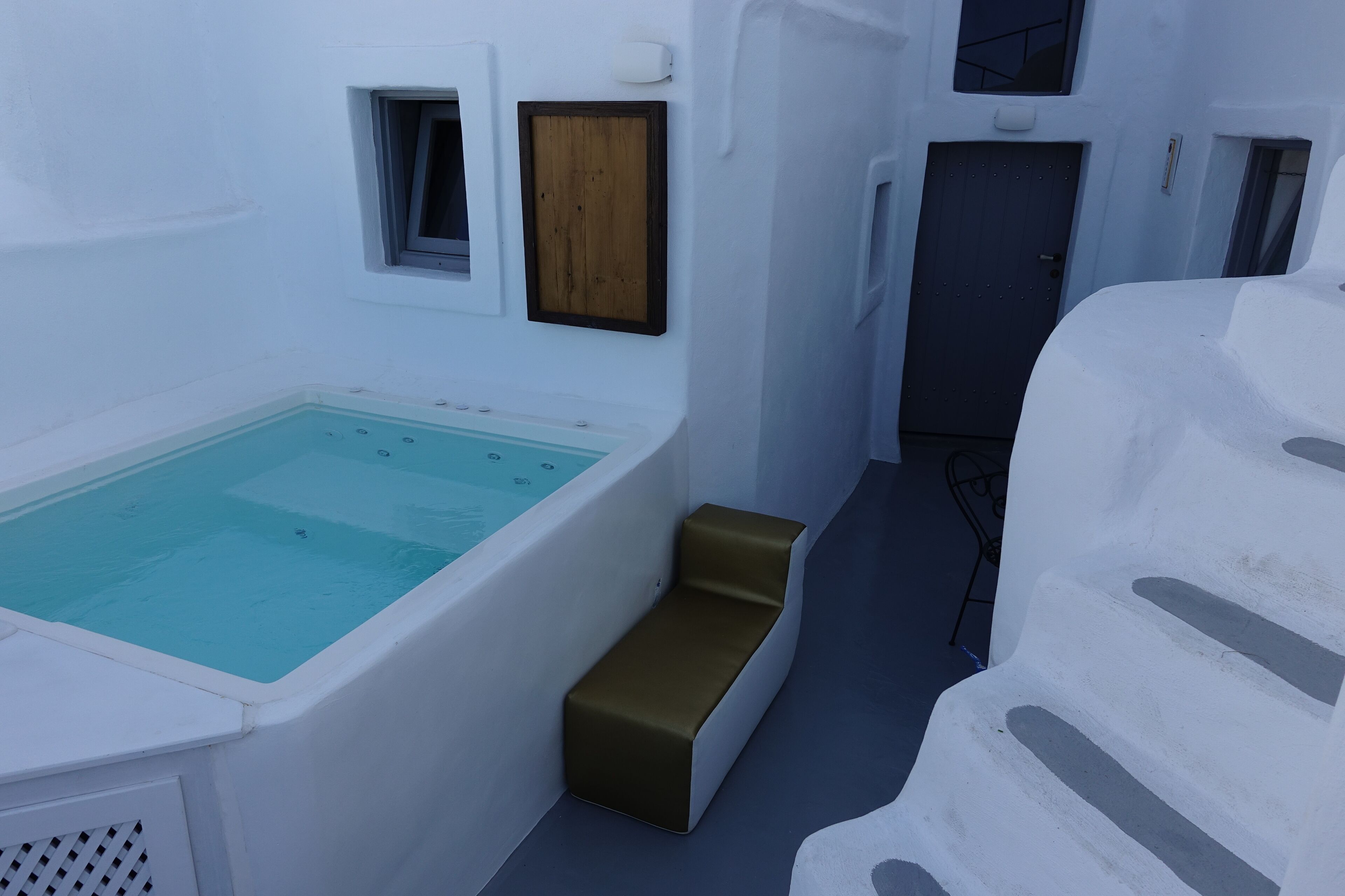 A spa area with a large bathtub, wooden door, and steps leading to a higher level.