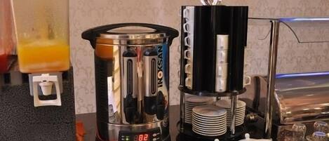 Una estación de café con una cafetera, un espumador de leche y un molinillo.
