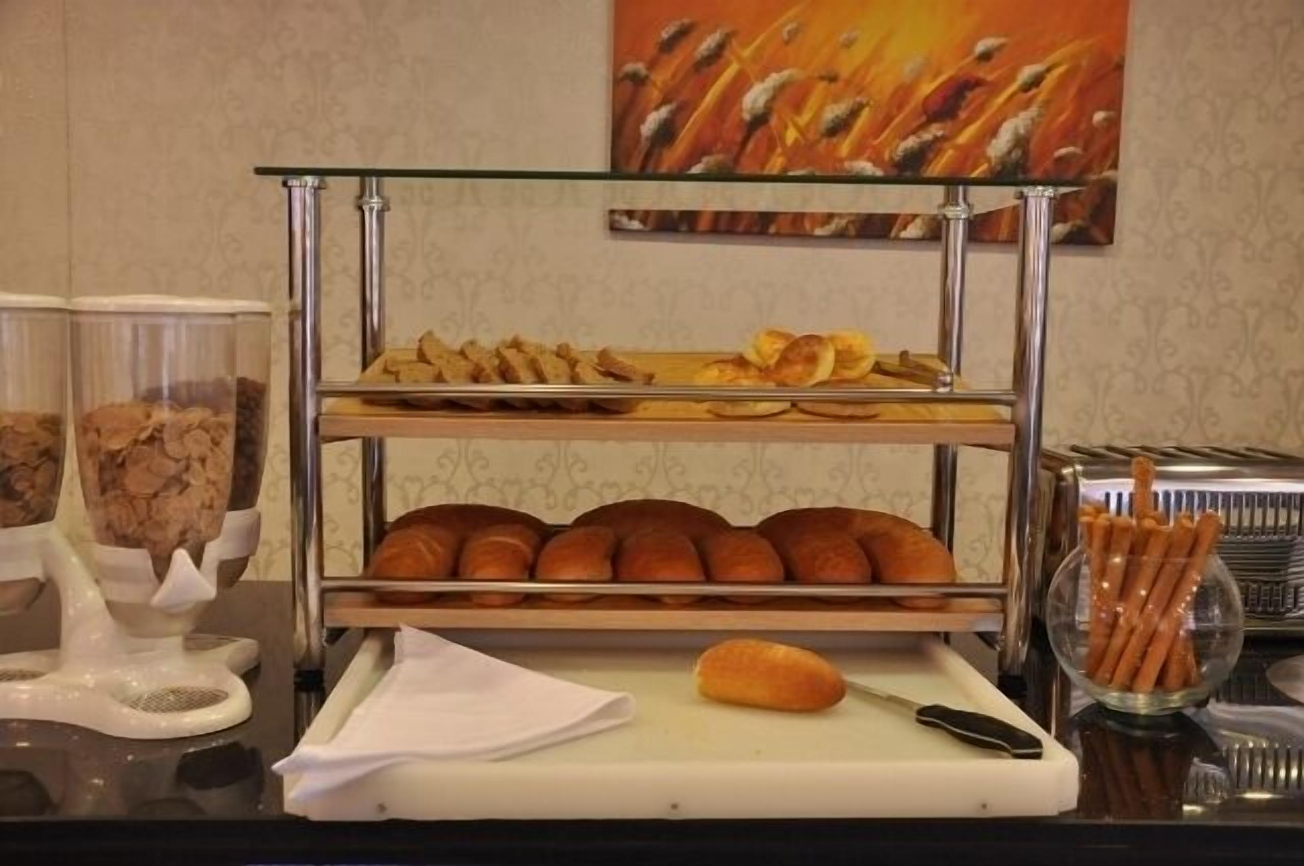 Ein Frühstücksbuffet mit Gebäck, Brot und einem Schneidebrett mit Messer.