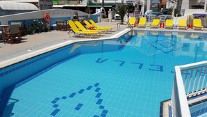 A swimming pool with a tiled edge and a lifeguard stand. - Villa Stella Apartments By Estia (Hersonissos)