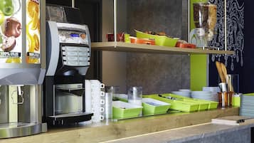 Une machine à café dotée d’un panneau de sélection, d’un distributeur de café et d’un comptoir avec des récipients et des ustensiles verts.
