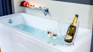Una bañera con una botella de champán y dos copas.