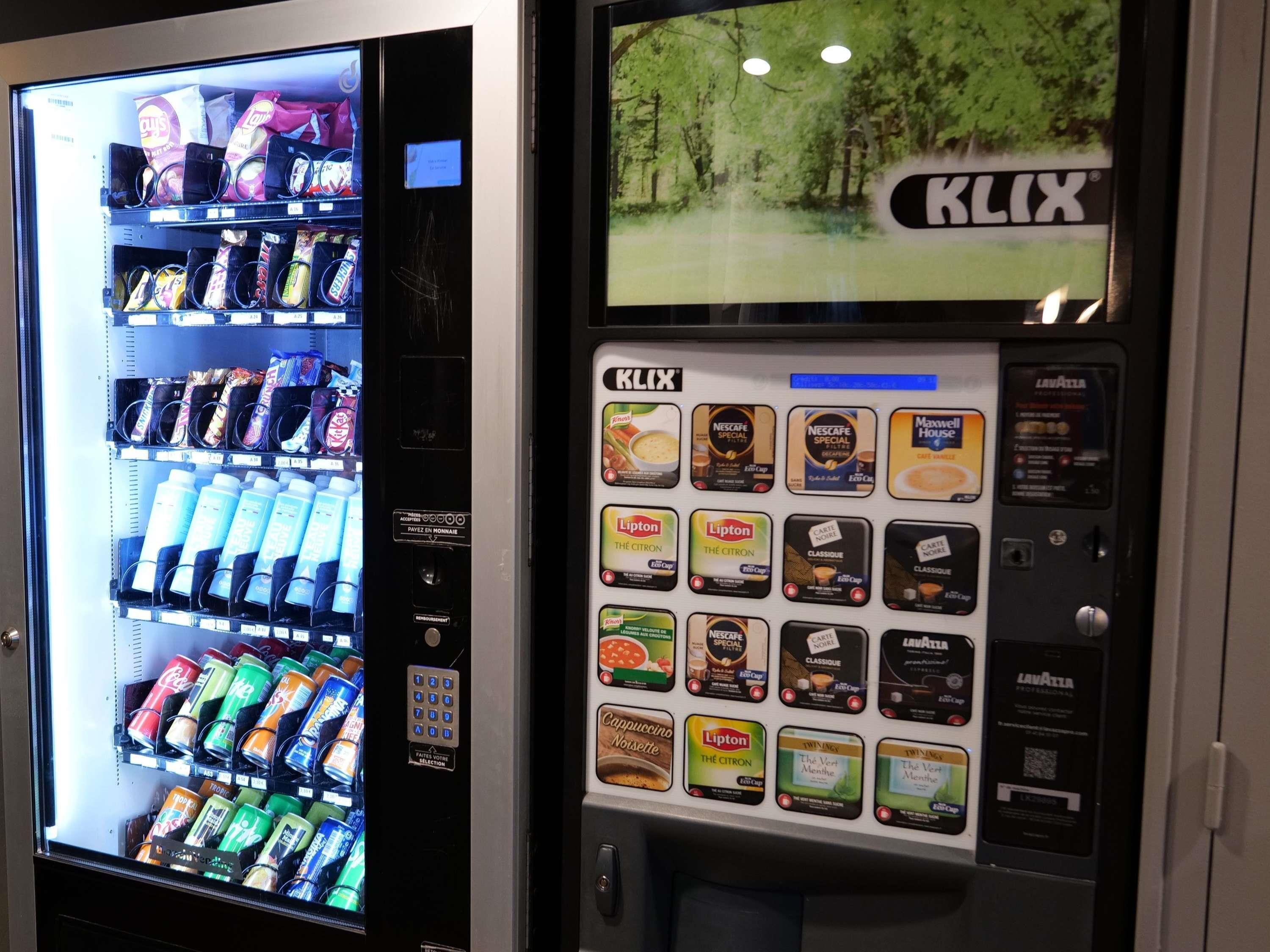 Una máquina expendedora con diversas opciones de bocadillos y bebidas, como papas fritas, refrescos y café.