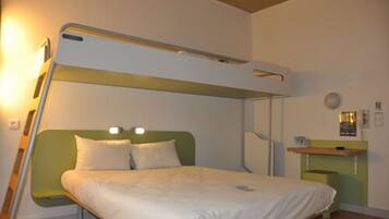A bunk bed with a green headboard and a bedside table with a lamp.