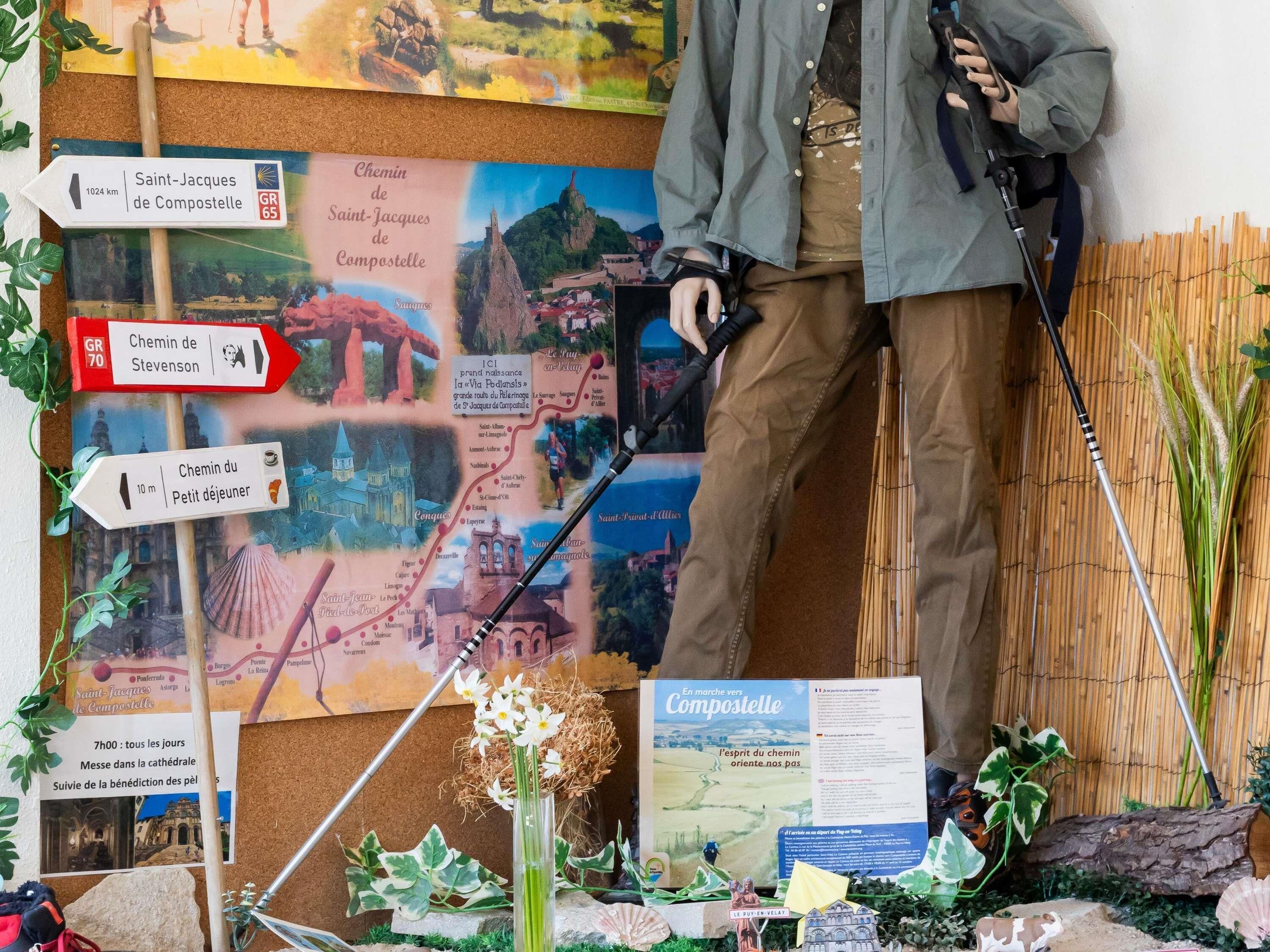 Un panneau d’information touristique comprenant des panneaux de signalisation, une carte et une maquette d’un petit village.