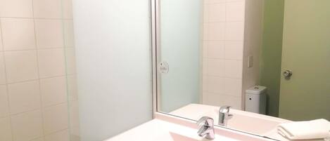 A bathroom with a white sink, a mirror, and a toilet.