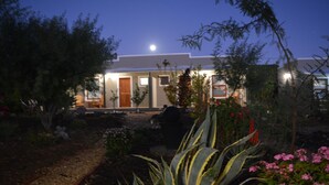 Moderni talo, jossa on hoidettu puutarha, hämärän aikaan.