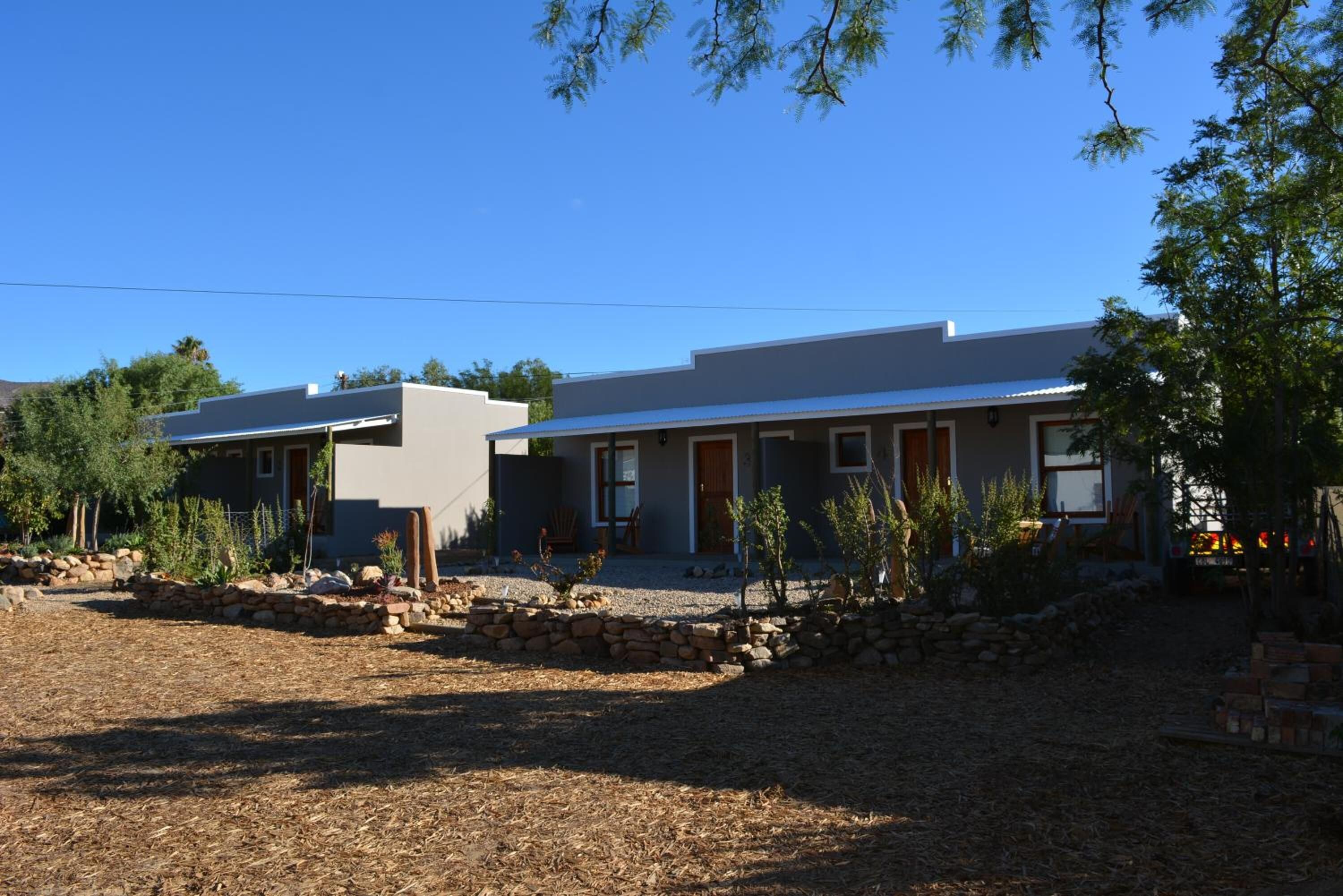 A modern two-story house with a stone foundation and a flat roof.