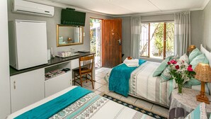 Une chambre d’hôtel avec deux lits, un bureau, une télévision et une fenêtre avec des rideaux.