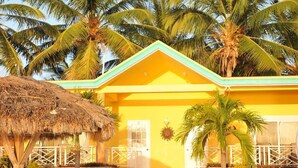 A yellow building with a green roof, surrounded by palm trees. - Abaka Bay Resort (Ile-a-Vache)