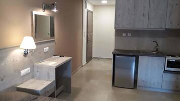 Cocina compacta con un lavabo, un refrigerador pequeño y una encimera.