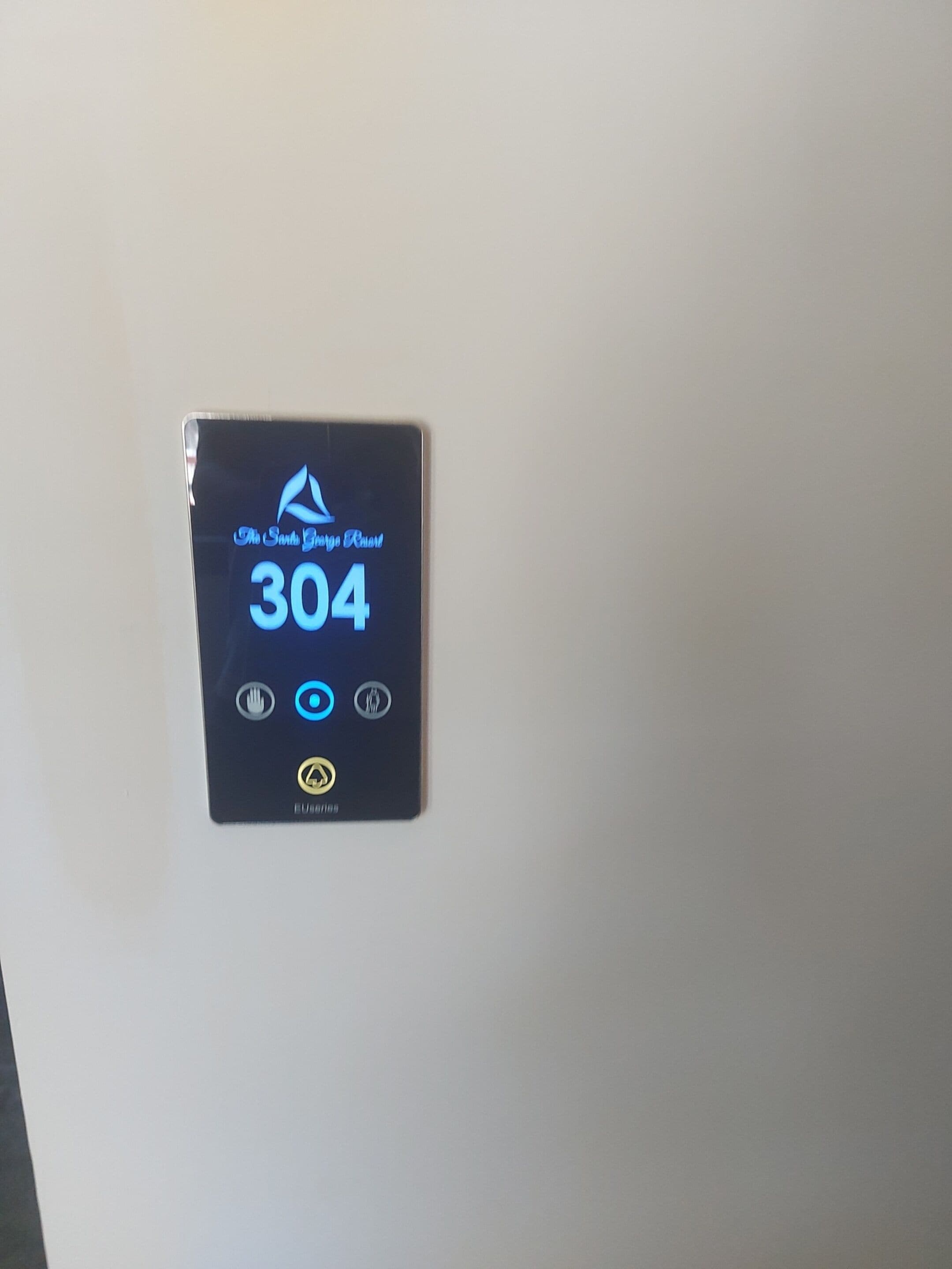 A digital display on a wall indicating room number 304 with icons for a hand, a bed, and a toilet.