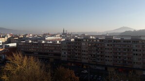 A multi-story building with a flat roof, likely a hotel or apartment complex, with a view of a distant mountain and a clear sky. - Apartment Alejní (Teplice)