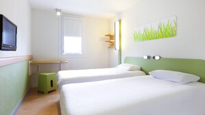 A hotel room with two beds, a desk, a small stool, a TV, a window, and a wall art piece. - ibis Budget Dax Saint Paul les Dax (Saint-Paul-les-Dax)