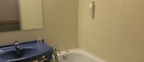 Une salle de bain avec un lavabo, un miroir et une baignoire.
