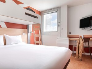 A hotel room with a bed, a desk, a television, a window, and a coat rack. - ibis Budget Caen Mondeville (Mondeville)