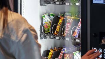 A vending machine with snacks and drinks, including brands like Twix and KitKat.
