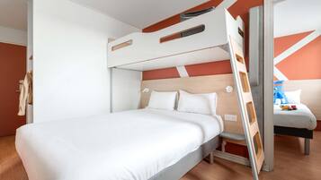 Een stapelbed met een houten hoofdbord, een nachtkastje en een klein zitgedeelte met een kussen en een speeltje.
