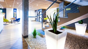 Un espace intérieur moderne doté d’un escalier, d’un coin salon et de plantes en pot.