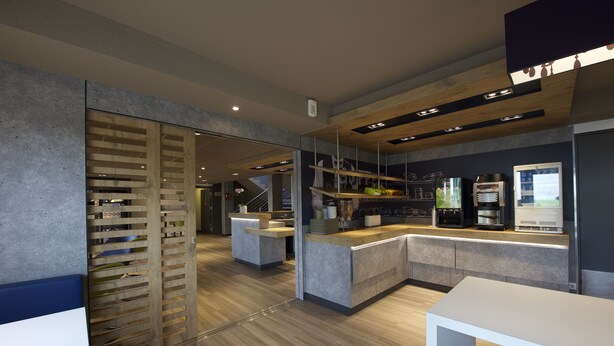 Une cuisine moderne aux accents boisés, dotée d’appareils électroménagers intégrés et d’un design épuré et contemporain.