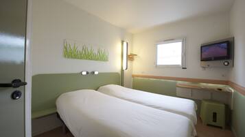 A room with two beds, a window, a television, and a small stool.