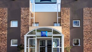 Un bâtiment moderne avec une enseigne indiquant la présence d’hôtels ibis budget.