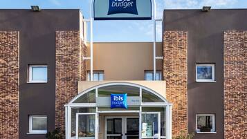 Un edificio moderno con un cartel de ibis budget hoteles.