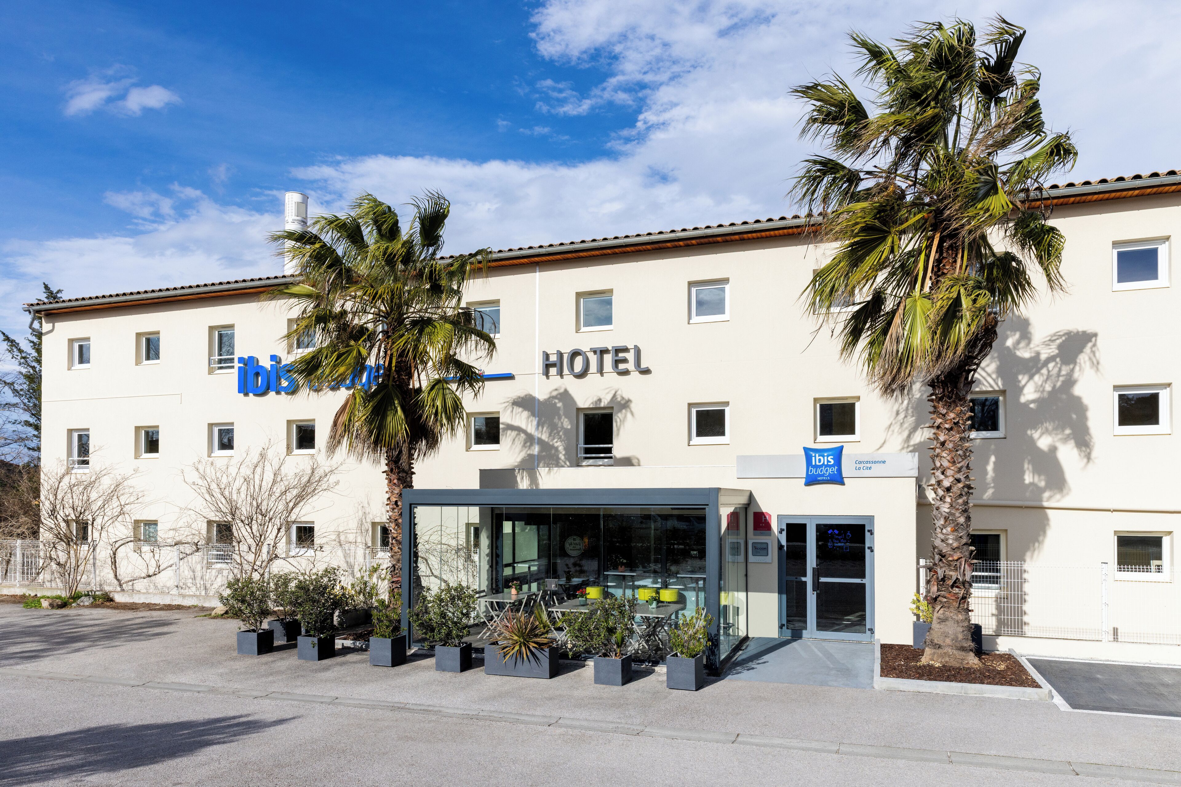 A hotel with a modern facade, multiple windows, and a glass entrance.