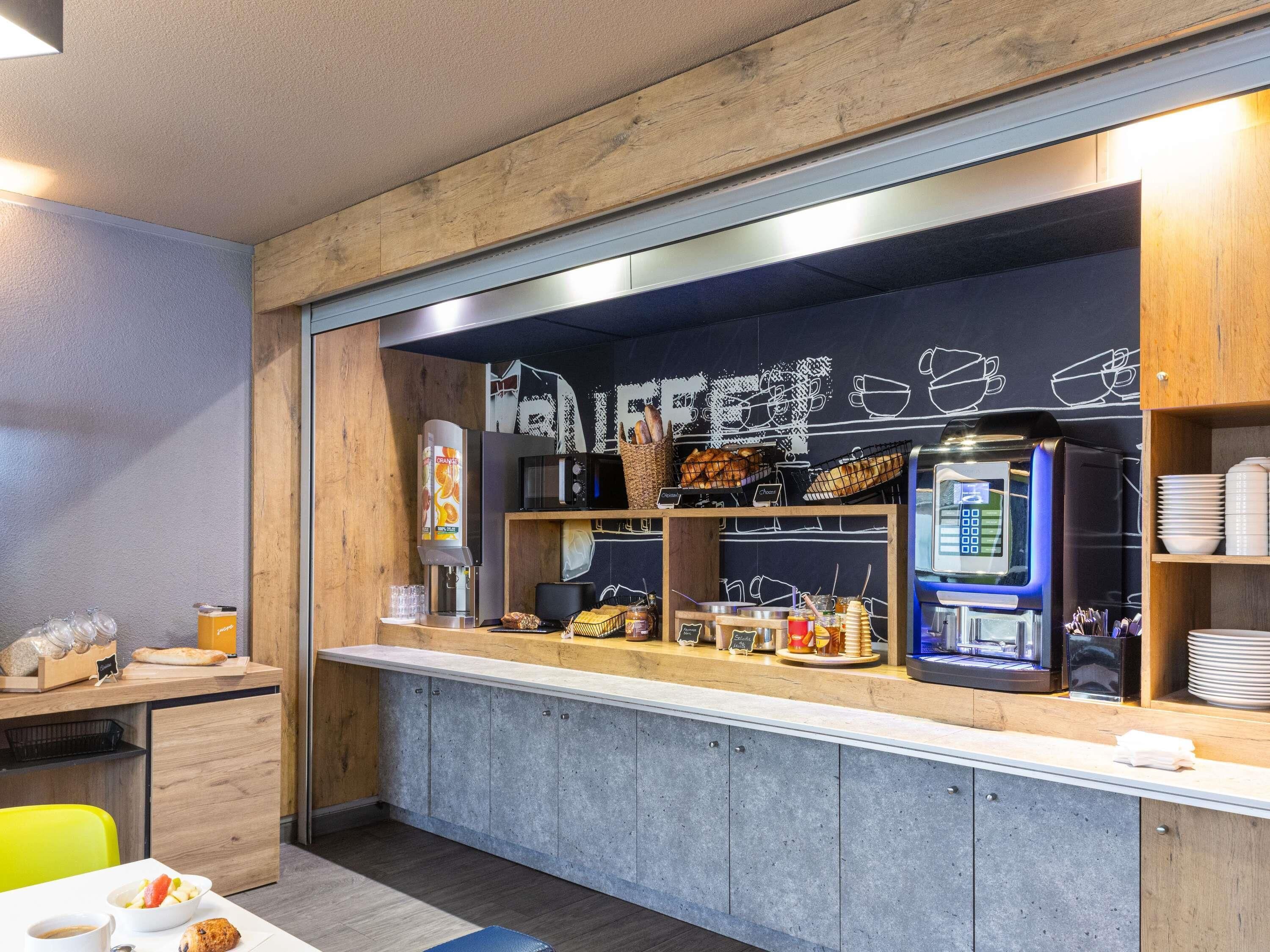 A café with a counter, seating area, and various food and drink items.