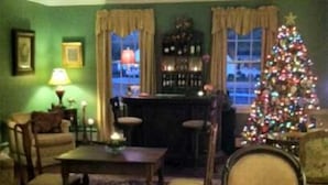 Una sala de estar acogedora con un árbol de Navidad, una zona de bar y vistas a la ciudad a través de las ventanas.