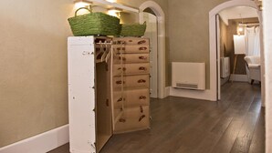A hallway with a white storage unit, wooden drawers, and a basket on top. - La Pampa Relais (Melizzano)